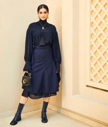 The sheer black dree with an interesting neckline is paired with a navy blue modern tie-skirt to great effect - Fashion Models
