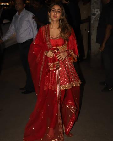 The bright red Anarkali with gold embroidery and embellishments has flared sleeves and the short skirt reminiscent of the Mughal age - Fashion Models